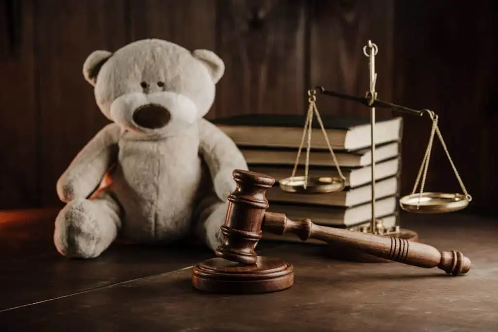 Teddy bear on desk with gavel and scale